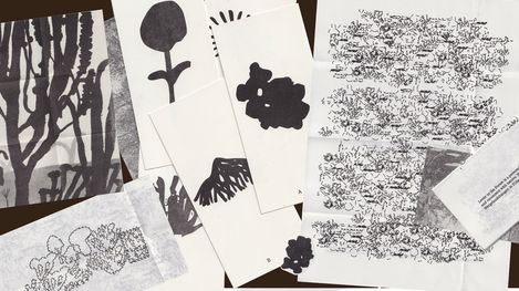 Several black-and-white sheets with abstract and floral patterns and handwritten texts overlapping on a light surface.