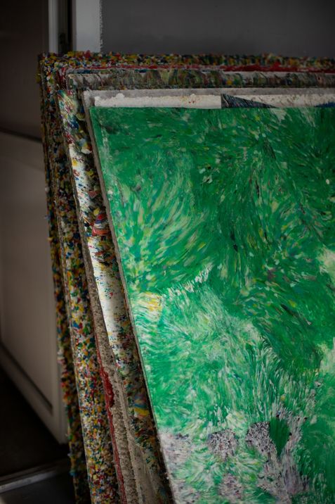 Stack of multiple recycled material panels with a green surface on the front