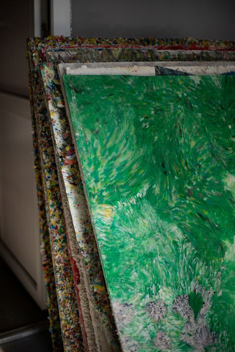 Stack of multiple recycled material panels with a green surface on the front