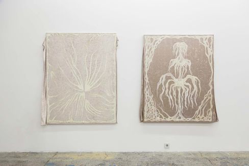 Two abstract paintings with organic root-like lines on canvases hanging on a white wall.
