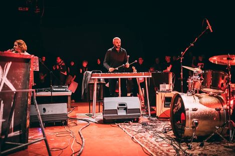 Musiker spielt auf einem Vibraphon auf einer Bühne mit Schlagzeug und weiteren Instrumenten im Hintergrund.