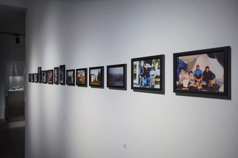 A series of framed photographs hanging on a white wall in an exhibition space.