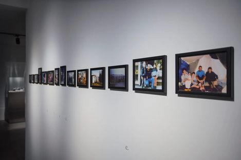 A series of framed photographs hanging on a white wall in an exhibition space.