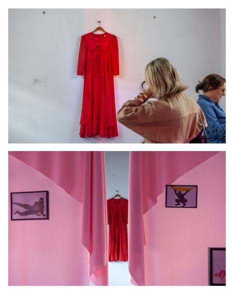 Oben hängt ein rotes Kleid an einer weißen Wand, davor stehen zwei Frauen, unten hängt dasselbe Kleid an einer Wand zwischen rosa Vorhängen, flankiert von zwei schwarz-weißen Fotografien mit liegenden und kauernden Figuren.
