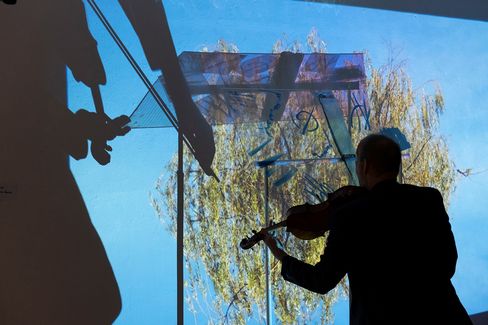 Silhouette einer Person, die Geige spielt, vor einer Glaswand mit Schatten und Baum im Hintergrund.