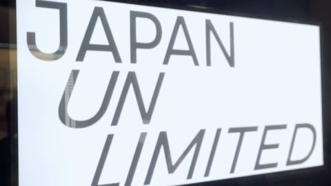 “Japan Unlimited” lettering in black on a white illuminated screen