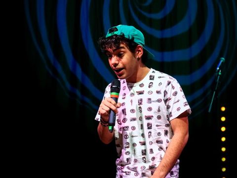 A young man is singing into a microphone.