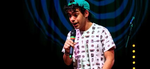 A young man is singing into a microphone.