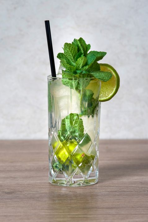 Mojito with fresh mint, lime slice and ice cubes in a tall glass