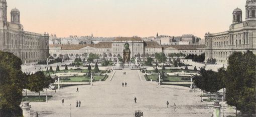 View of Maria-Theresien-Platz in Vienna with the monument in the centre, surrounded by symmetrically laid out gardens and large buildings on both sides, with the MuseumsQuartier Wien, formerly the Imperial Stables, behind it