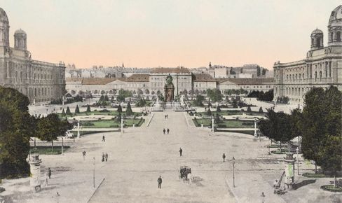 View of Maria-Theresien-Platz in Vienna with the monument in the centre, surrounded by symmetrically laid out gardens and large buildings on both sides, with the MuseumsQuartier Wien, formerly the Imperial Stables, behind it