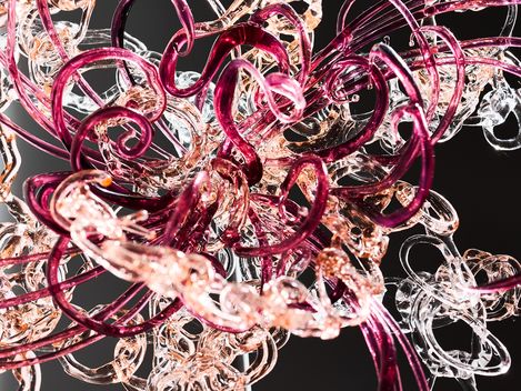 Close-up of a delicate spiral structure made of transparent and purple material against a black background
