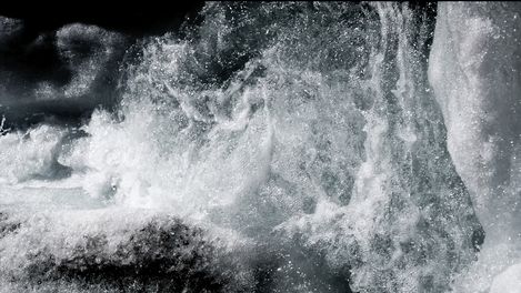Nahaufnahme von spritzendem Wasser mit sichtbaren Blasen und Schaum.