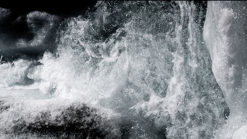 Nahaufnahme von spritzendem Wasser mit sichtbaren Blasen und Schaum.