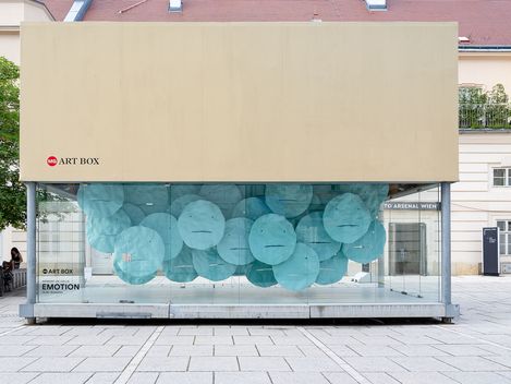 MQ Art Box in MuseumsQuartier Vienna featuring the installation “EMOTION” by Herbert de Colle, composed of numerous turquoise floating face-like forms.