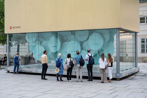 Visitors observe the installation “EMOTION” in the MQ Art Box through the glass façade.
