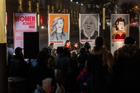 Eröffnung der Installation „Frauen gegen den Krieg“, 2025. Drei Frauen halten vor den Ausstellungsplakaten eine Rede vor Publikum.