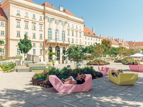 Innenhof mit Enzis in gelb und rosa auf dem MQ Haupthof and einem sonnigen Tag.