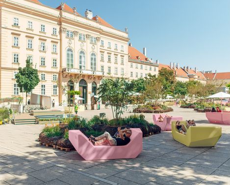 Innenhof mit Enzis in gelb und rosa auf dem MQ Haupthof and einem sonnigen Tag.
