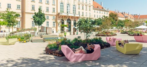 Courtyard with yellow and pink Enzis on the main courtyard of the MQ on a sunny day.