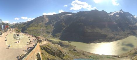View from the Kaiser-Franz-Josefs-Höhe over the Alpine mountain landscape and glacial lake, with a pink Enzi visible in the foreground.
