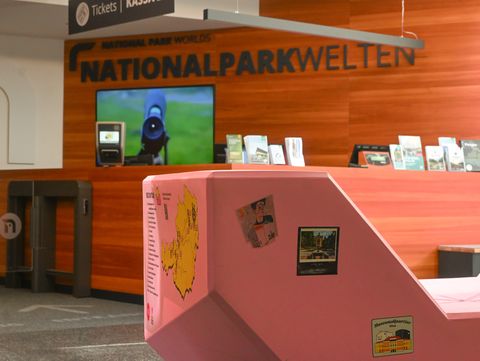 Rosa Enzi mit Aufklebern verschiedener Stationen seiner Tour im Eingangsbereich der Nationalparkwelten Hohe Tauern.