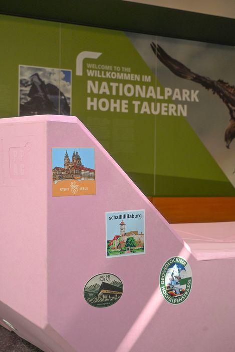 Rosa Enzi mit mehreren Aufklebern vor der Ausstellung im Nationalpark Hohe Tauern.