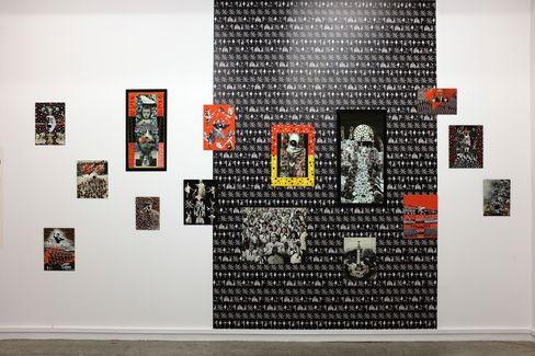 Wall installation with multiple small rectangular collages and photographs arranged on a large black-and-white patterned background.
