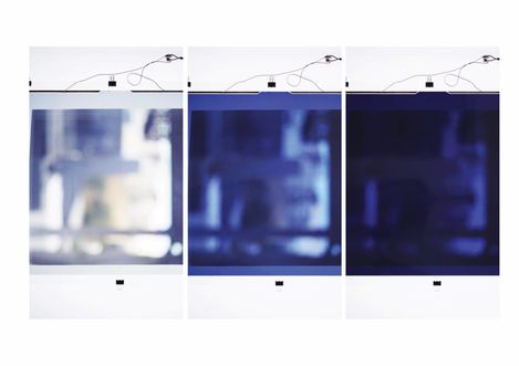 Three blurry square color fields side by side each with a black clip at top and bottom and a black line with clamp above.