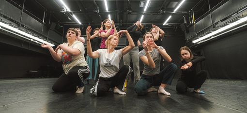 Dancers are depicted in a choreographed pose.