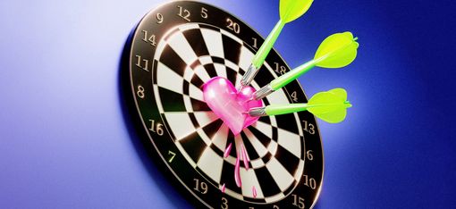 The picture shows a dartboard. In the centre is a heart that has been hit by three darts.