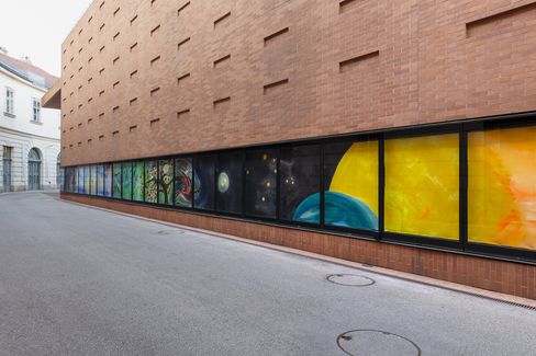 Colorful painting installation with painted elements such as trees and planets on a brick facade of the Kunsthalle Wien.