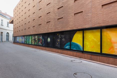 Colorful painting installation with painted elements such as trees and planets on a brick facade of the Kunsthalle Wien.