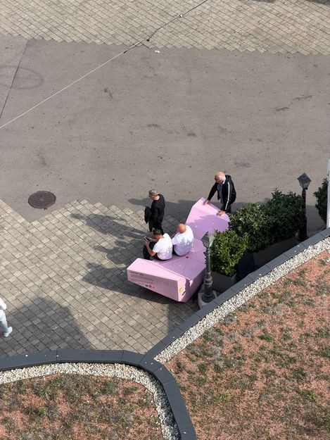 Blick von oben auf mehrere Personen rund um einen rosa Enzi beim Wiener Riesenrad.