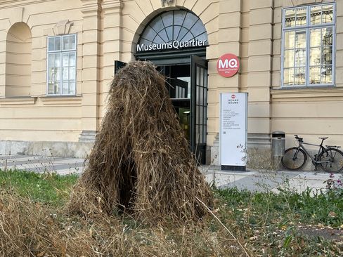 A haystack shaped like the letter “A” is in the foreground. An MQ entrance can be seen in the background.