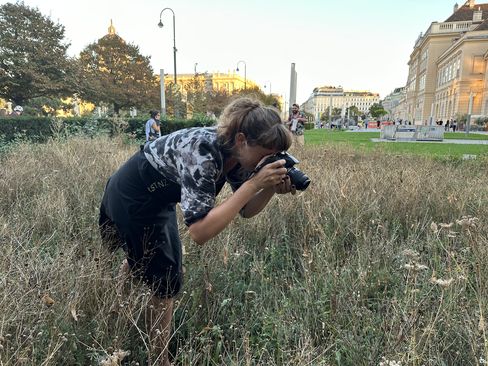 A woman is photographing a flower in the Versuchsfeld1