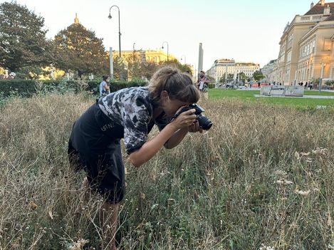 A woman is photographing a flower in the Versuchsfeld1