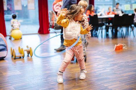 A girl is playing hula-hoop.