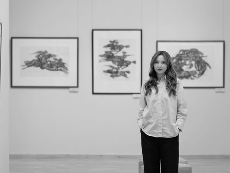 black and white portrait picture of a woman standing in a museum