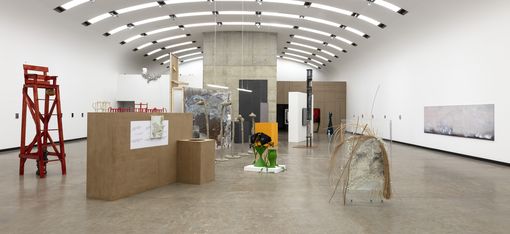 Ein Ausstellungsraum mit mehreren Skulpturen und Gemälden.