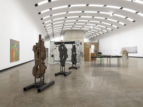 Ein Ausstellungsraum mit mehreren Skulpturen und Gemälden.