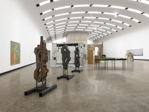 An exhibition space featuring several sculptures and paintings.
