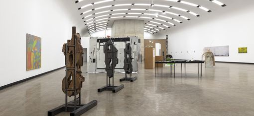 Ein Ausstellungsraum mit mehreren Skulpturen und Gemälden.