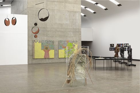 Ein Ausstellungsraum mit mehreren Skulpturen und Gemälden.