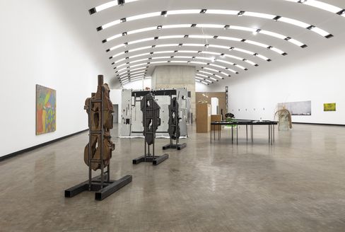 Ein Ausstellungsraum mit mehreren Skulpturen und Gemälden.