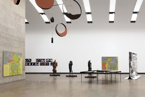Ein Ausstellungsraum mit mehreren Skulpturen und Gemälden.