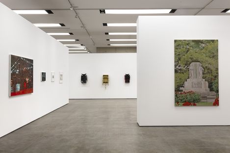 Ein Ausstellungsraum mit eingezogenen Wänden, an denen unterschiedliche große Gemälde von Judith Eisler, Lukas Kaufmann und Dario Wokurka hängen.
