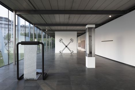 In einem länglichen Ausstellungsraum stehen mehrere Skulpturen aus Metall und weiteren Materialien.