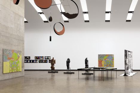 Ein Ausstellungsraum mit mehreren Skulpturen und Gemälden.