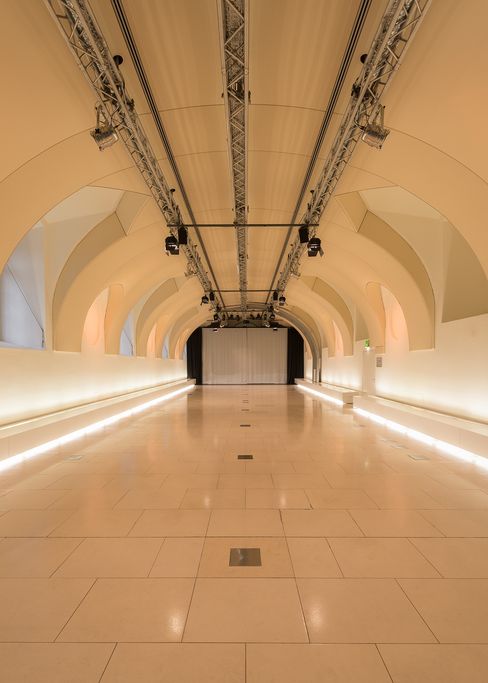 Großer Veranstaltungsraum Arena21 im MuseumsQuartier Wien mit gewölbter Decke und einer Leinwand am Ende des Raums.
